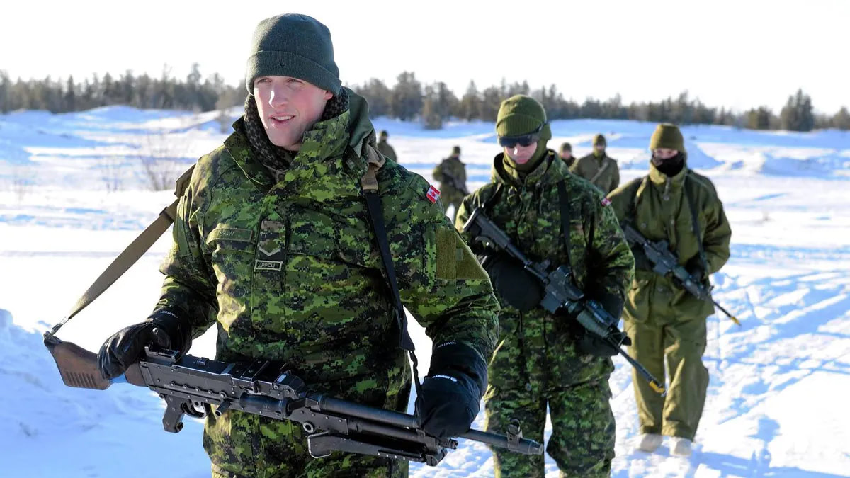 Soldiers equipped with rifles march through snow