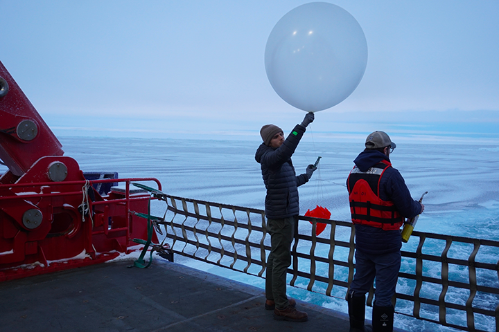 Zach Burchfield on research boat launching a weather balloon